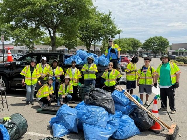 The EcoClean Guardians Eco Earner team in hi-vis vests with bags of collected litter after a New Jersey cleanup