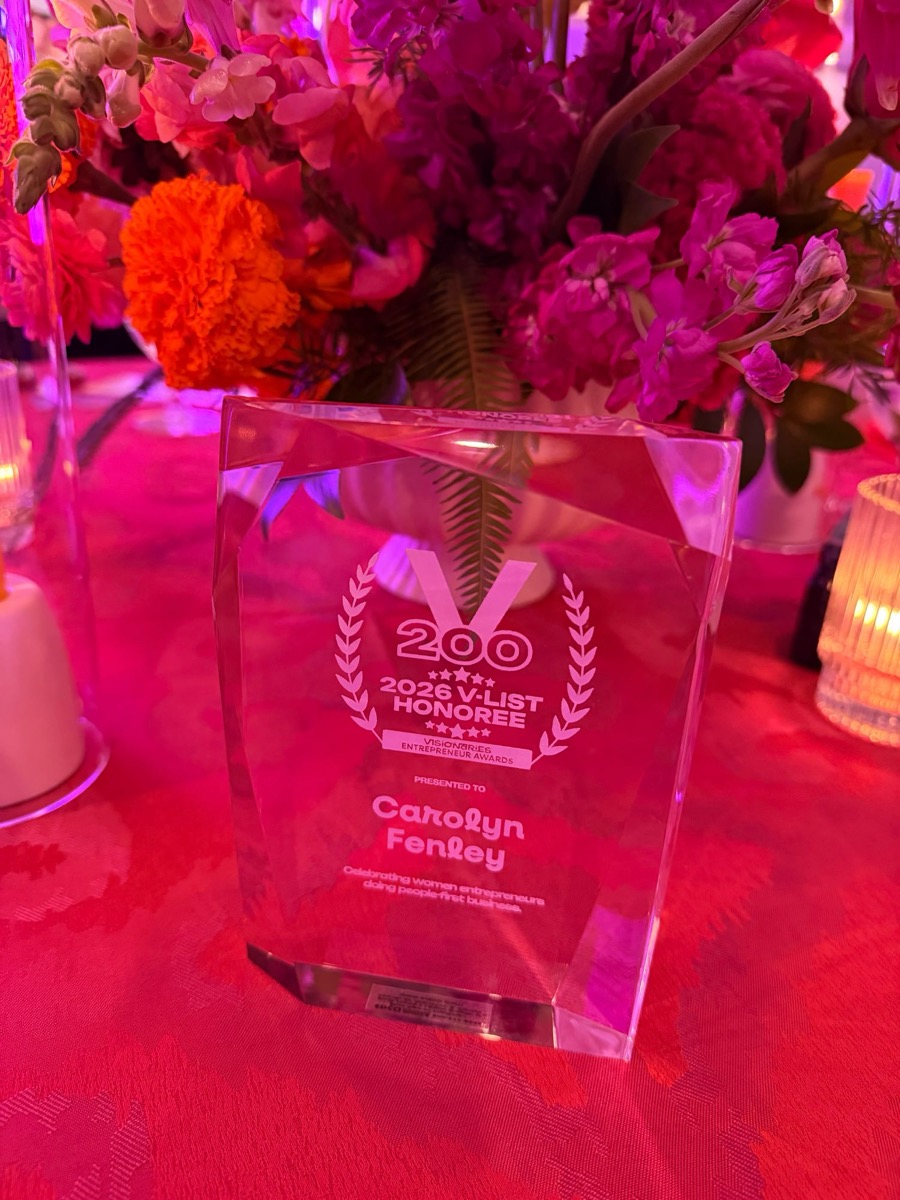 The 2026 V-List Honoree crystal award from the Visionaries Entrepreneur Awards, engraved "Presented to Carolyn Fenley"
